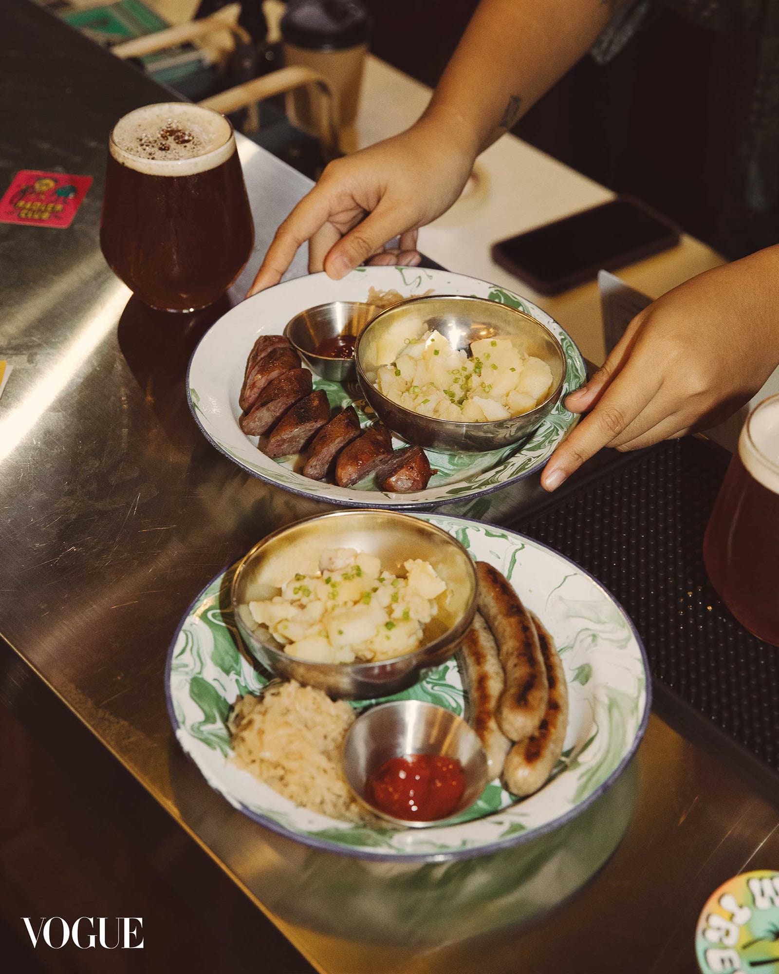 Grilled sausage plates with potato salad and dipping sauces, served with craft beer